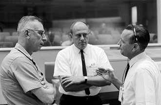 Em 1965, o contra-almirante W.C. Abhau (à esquerda), é mostrado no Centro de Controle da Missão com Bob Thompson (centro) e Chris Kraft, diretor de vôo da Gemini-5.
