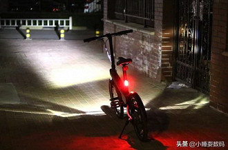 Xiaomi QiCycle a noite com farol dianteiro e traseiro acesos. Fonte: electrek.co