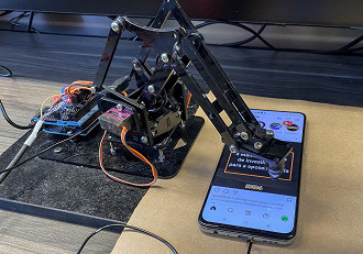 Braço robótico auxiliando no teste de bateria
