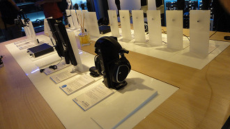 Bancada no centro do showroom do Sennheiser Experience com diversos fones de ouvido e microfones expostos. Fonte: Vitor Valeri