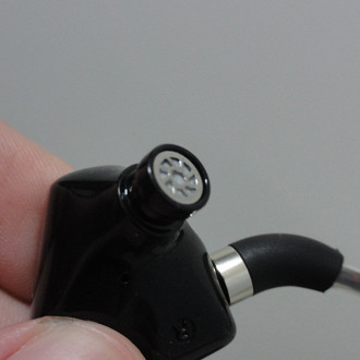 Nozzle (bocal por onde sai o som) de um fone de ouvido in-ear cabeado.